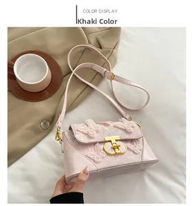 Detailed close-up of khaki embroidered butterfly pattern and metal T-lock on handbag