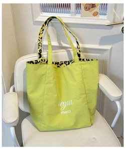 Detail of green canvas tote bag featuring white text and leopard print inner lining