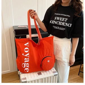 Détail du grand sac cabas en nylon orange avec imprimé voyage et petite pochette