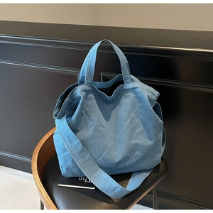 Detailed macro view of the blue denim fabric texture on this minimalist large tote bag