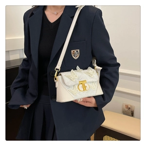 Close-up of white square crossbody bag featuring delicate 3D butterfly embroidery and gold lock