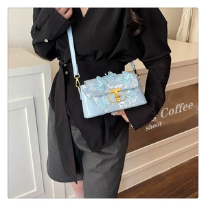 Close-up of light blue crossbody bag with 3D butterfly embroidery and gold metal clasp