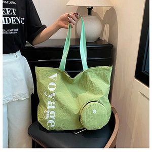 Détail du sac cabas en toile lavée verte avec imprimé voyage et petite pochette assortie