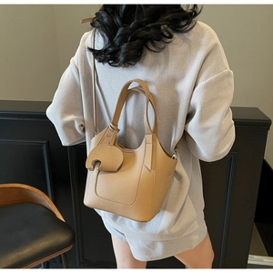 Detail of lychee pattern leather bucket bag with cute elephant charm and crossbody strap
