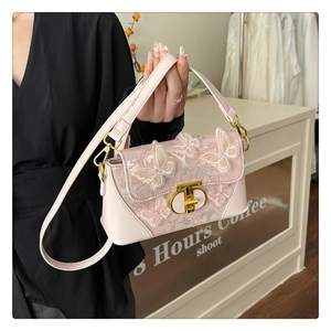 Close-up of pink crossbody bag with 3D butterfly lace and golden CD twist lock clasp