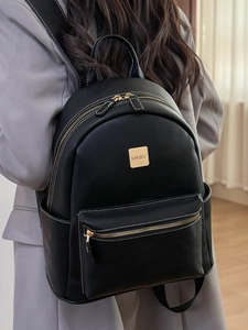 Chic black leather backpack with white stitching and gold hardware on a female model