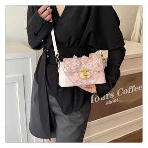 Close-up of pink square bag featuring 3D butterfly embroidery and gold metal clasp detail