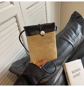 Detail of woven straw crossbody bag with black leather top and elegant pearl buckle closure