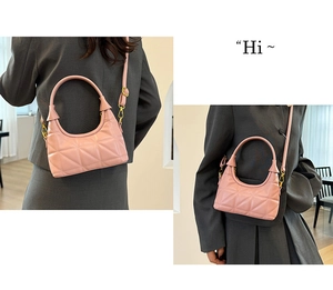 Detail view of pink quilted hobo bag with sleek fixed handle and detachable strap