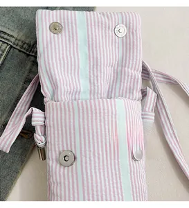 Close-up of pink striped fabric phone bag featuring secure silver magnetic buckle closure