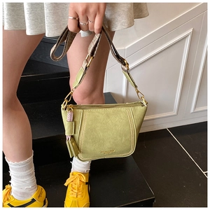 Detail of light green dumpling crossbody bag with textured leather and jacquard wide strap
