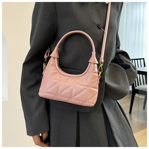 Pink quilted crossbody bag shown on model with tailored blazer for chic look