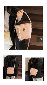 Détail du sac seau rose avec texture litchi fermoir métallique et pompon tressé