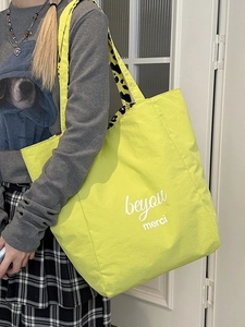 Neon green large tote bag with leopard print straps and beyou merci print on model