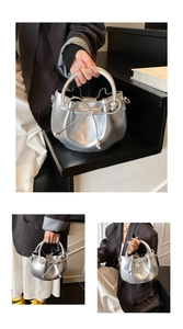 Close-up of silver metallic bucket bag featuring bow drawstring and curved handle details