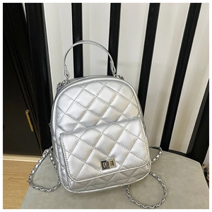 Detailed macro view of silver quilted backpack with chain straps and metal twist lock