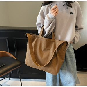 Detailed macro view of brown canvas tote bag texture and durable shoulder strap stitching