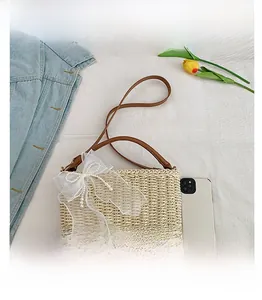 Detail of straw bag with mesh bow and pearls on white fabric background with tulips