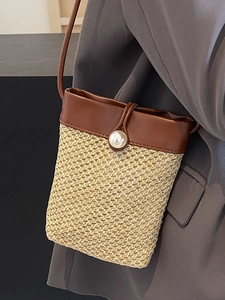 Handmade woven straw crossbody phone bag with leather trim and decorative pearl clasp