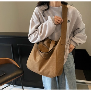 Close-up of wide canvas shoulder strap on minimalist brown tote bag with high-quality texture