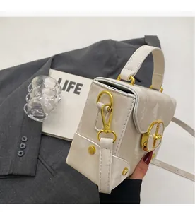 Close-up of marble pattern box bag with gold circular hardware and beige leather texture