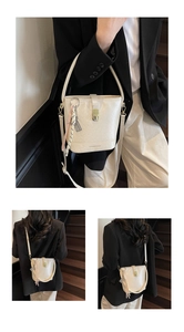 Détails du sac seau beige avec fermoir doré, texture cuir et foulard imprimé élégant