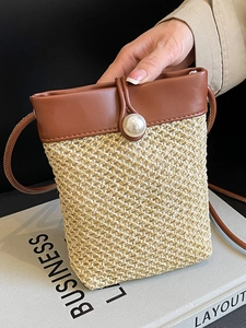 Straw mini crossbody bag with brown faux leather trim and pearl buckle for beach vacation