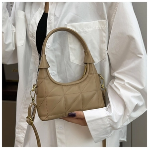 Detailed view of khaki quilted underarm bag featuring triangle stitching and gold hardware