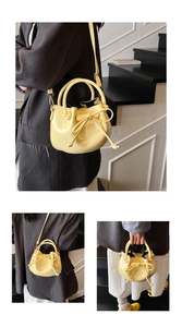 Fashionable bright yellow oil wax leather bucket bag with bow tie shown in lifestyle shot