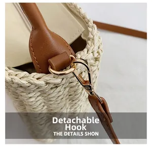 Detail of detachable golden alloy hook and brown leather handle on straw bag