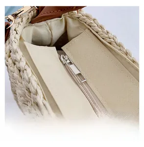 Detail shot of smooth metal zipper closure and fabric lining on handwoven straw beach bag