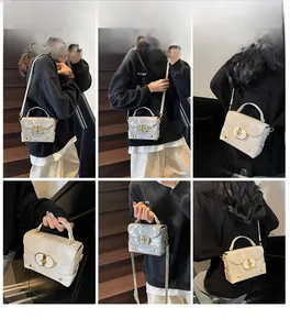 Multiple views of a marble grey mini box bag with gold hardware on wooden stairs