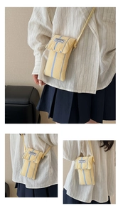 Detailed view of yellow and blue striped mini canvas phone bag with shoulder strap