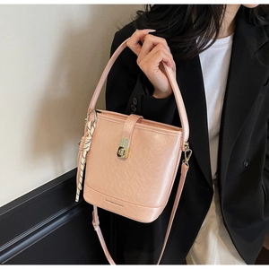 Sac seau rose en cuir grainé avec fermoir rotatif et pendentif en corde tressée