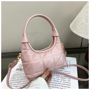 Detailed close-up of pink quilted underarm bag with gold metal hooks and shoulder strap