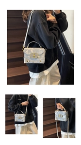 Detail of grey marble textured handbag with gold metal clasp and adjustable strap