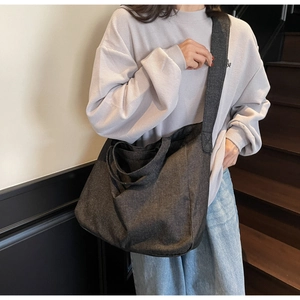 Macro detail of the durable thick canvas texture on a large minimalist dark grey tote bag
