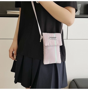 Detailed close-up of pink and white striped fabric phone bag with Fashion Instinct label