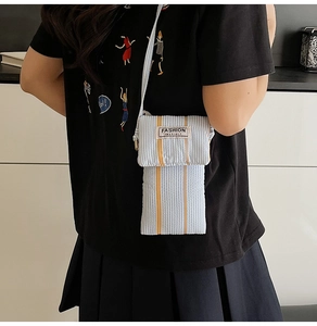 Close-up of blue and white striped crossbody phone bag with yellow vertical lines