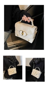 Macro shot of ivory white leather bag featuring a bold gold oval buckle and fine texture