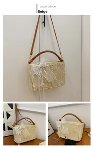 Detail view of beige woven straw bag featuring a white lace bow and pearl accents