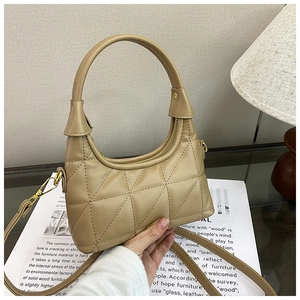 Detail of khaki quilted hobo bag featuring fine triangular stitching and golden metal hooks