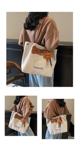 Detalle de bolsa tote de lona con correas marrones y bolsillo con cremallera en forma de hueso