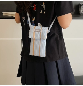 Vertical blue and white striped canvas phone bag with orange stripe and fashion label detail