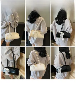 Detailansicht der französischen Schultertasche mit eleganter Spitzenschleife und Lederriemen
