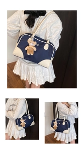 Detail of the vintage navy tote bag showing the plush bear charm and white brand lettering