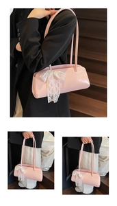 Detail der rosa Baguette-Tasche mit Spitzenschleife am Arm in einer Lifestyle-Szene