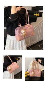 Detail of pink nylon pillow bag with logo print and cute teddy bear pendant charm