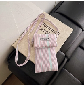 Detailed close-up of striped fabric texture and fashion instinct label on crossbody phone bag