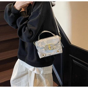 Detail of elegant gray marbled box bag featuring gold metallic clasp and corner guards